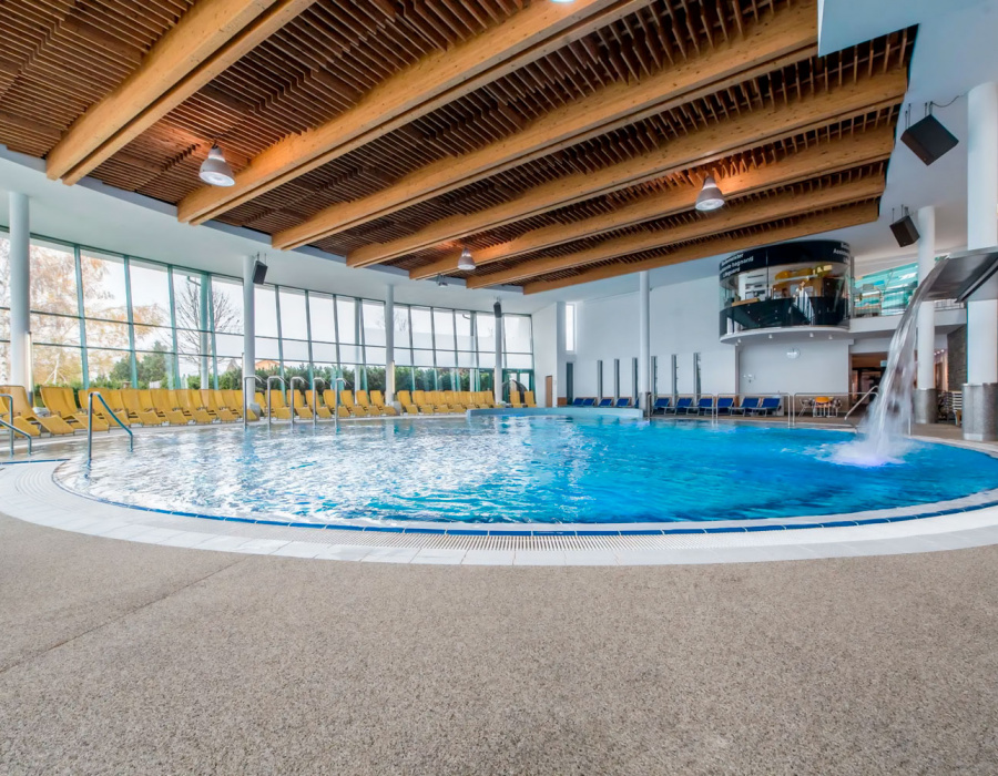 Pavimento in sasso resina drenante Isoplam intorno a piscina coperta con getto d’acqua