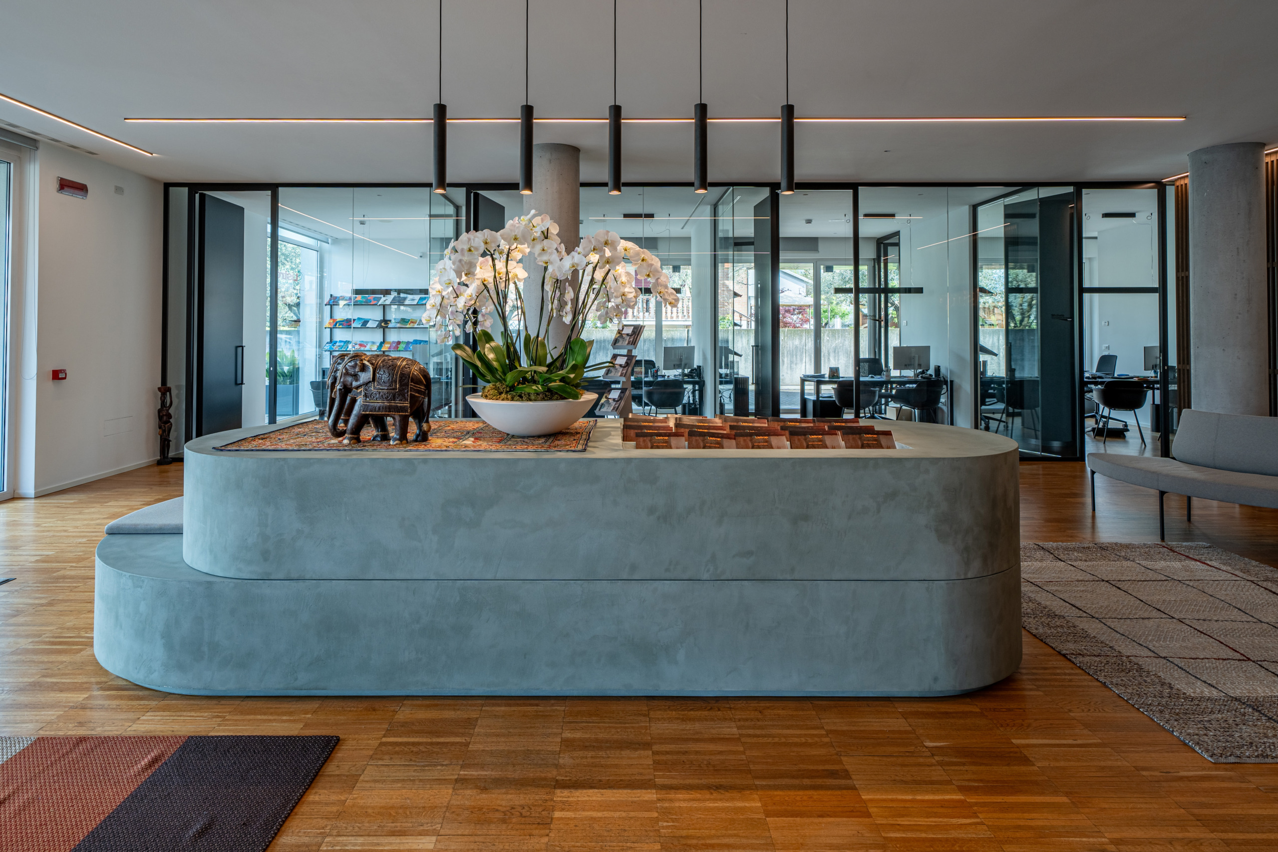 Rivestimento in microcemento Microverlay Isoplam su mobili e complementi, colori Stardust Gray, Medium Gray e Light Blue, progetto Durante Ufficio srl per Listrop Viaggi Rosà Vicenza.