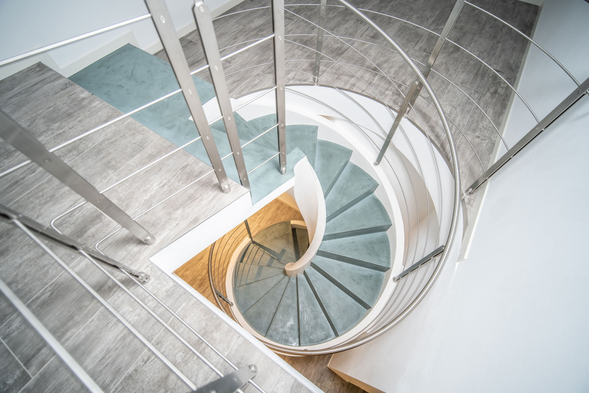 Scala a chiocciola in cemento resina Micro Compact Isoplam finitura Light Blue.