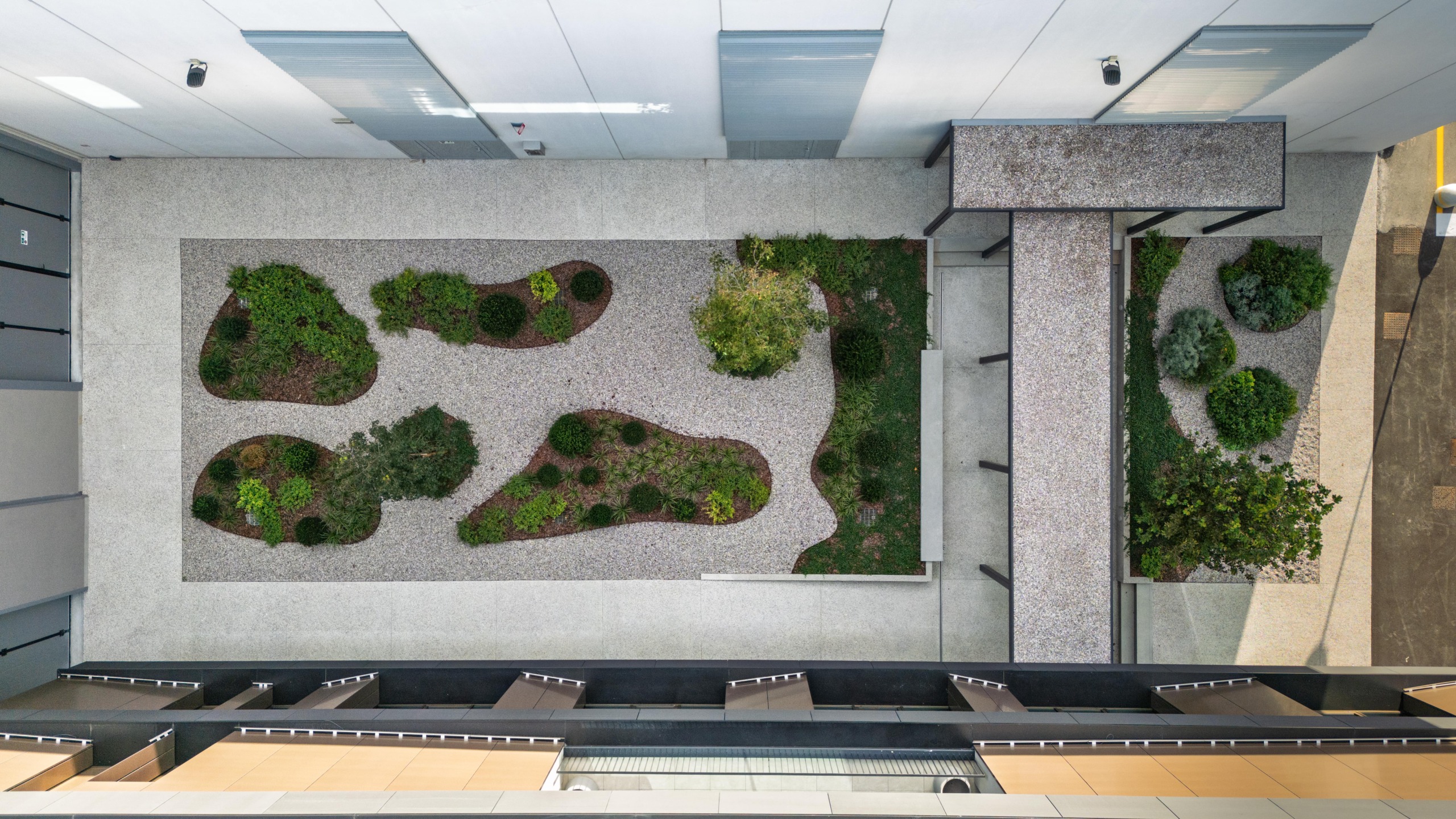 Vista aerea del cortile interno con pavimentazione in Italian Terrazzo Ghiaino Lavato Isoplam e aiuole verdi integrate
