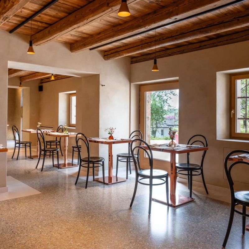 Pavimenti Continui a Basso Spessore: Inserire la Maxi Veneziana a Capitolato Pavimento effetto maxi veneziana Terrazzoverlay XL nella sala colazioni di un B&B con travi in legno a vista e ambienti luminosi