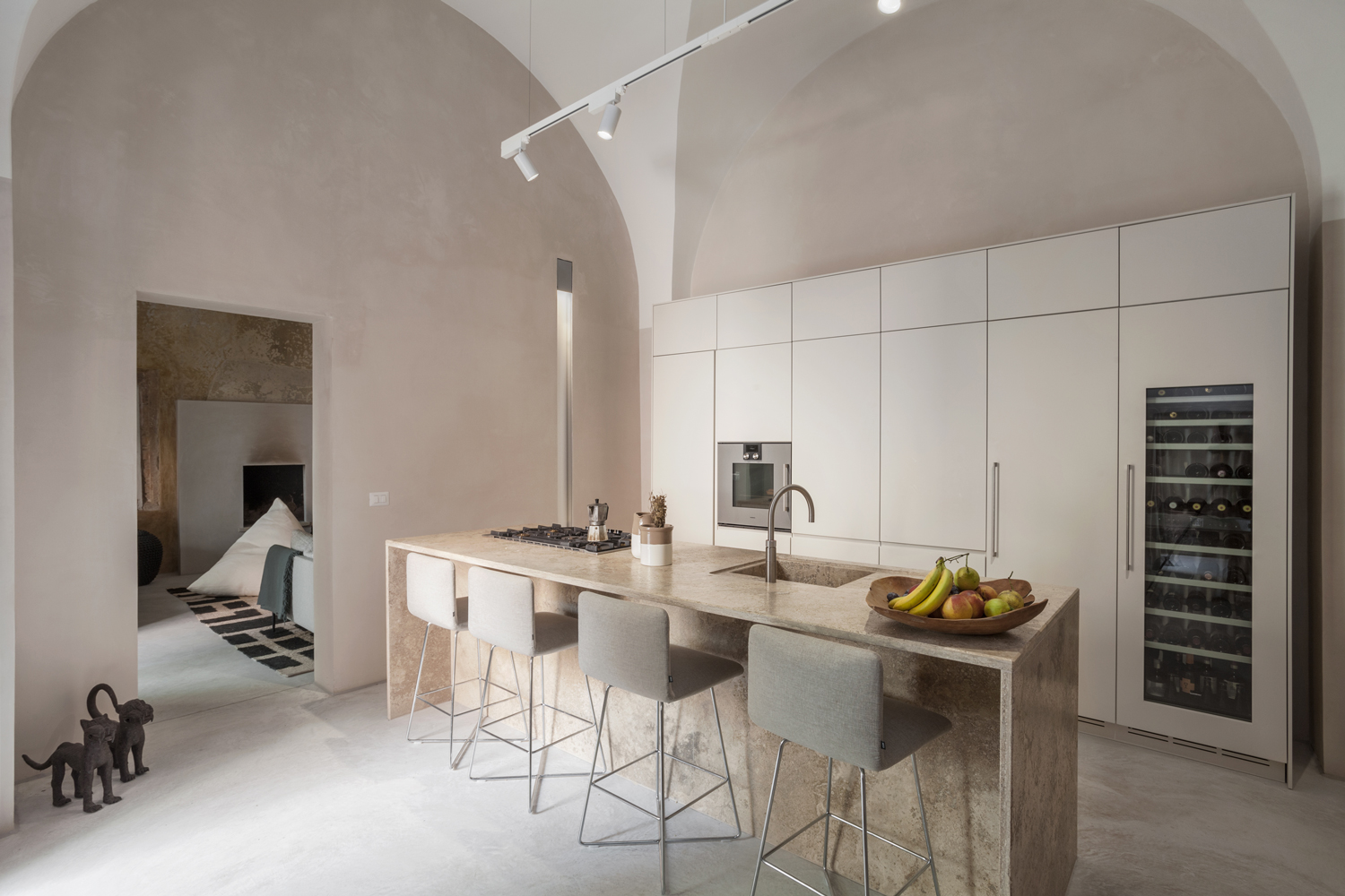 Cucina con isola in marmo e pavimentazione Deco Nuvolato cemento opaco, progetto Arch. Reuter+Schmidt a Nardò