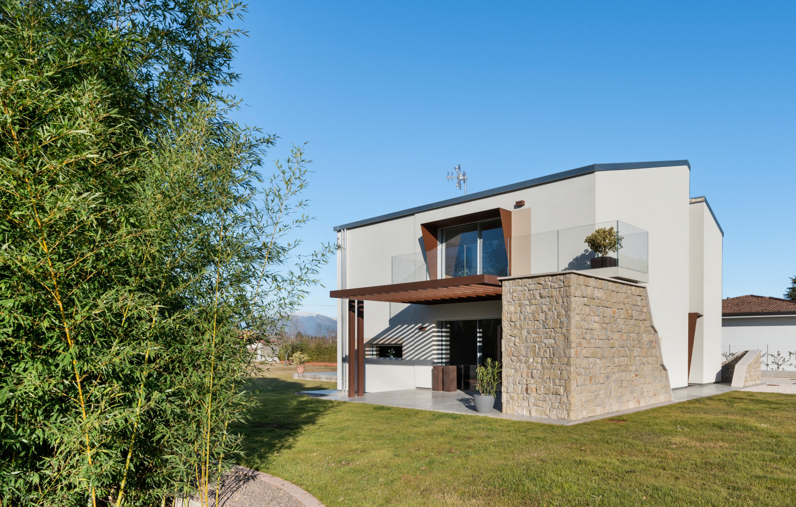 Casa Bioclima immersa nel giardino con pavimentazione esterna in cemento decorativo Deco Nuvolato