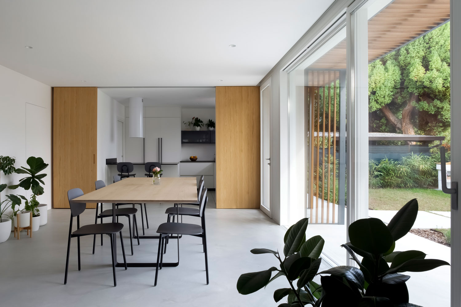 Zona giorno minimalista con pavimento in cemento Nuvolato Mineral Gray e arredi in legno naturale