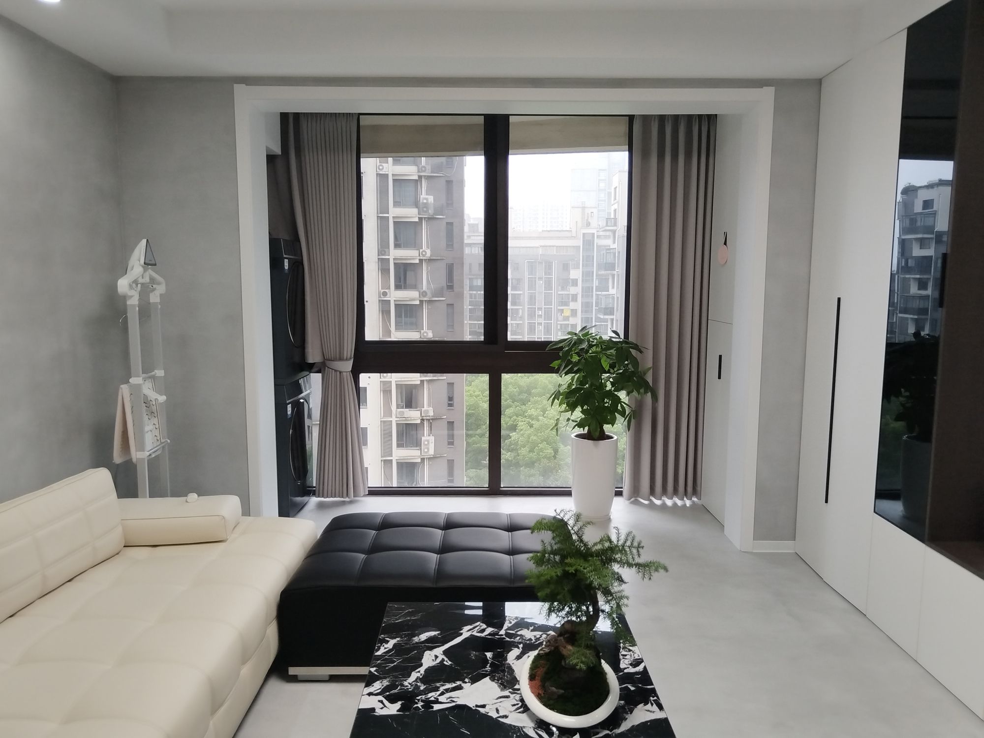 Living con pavimento continuo in microcemento grigio chiaro Microverlay e tavolino marmo nero