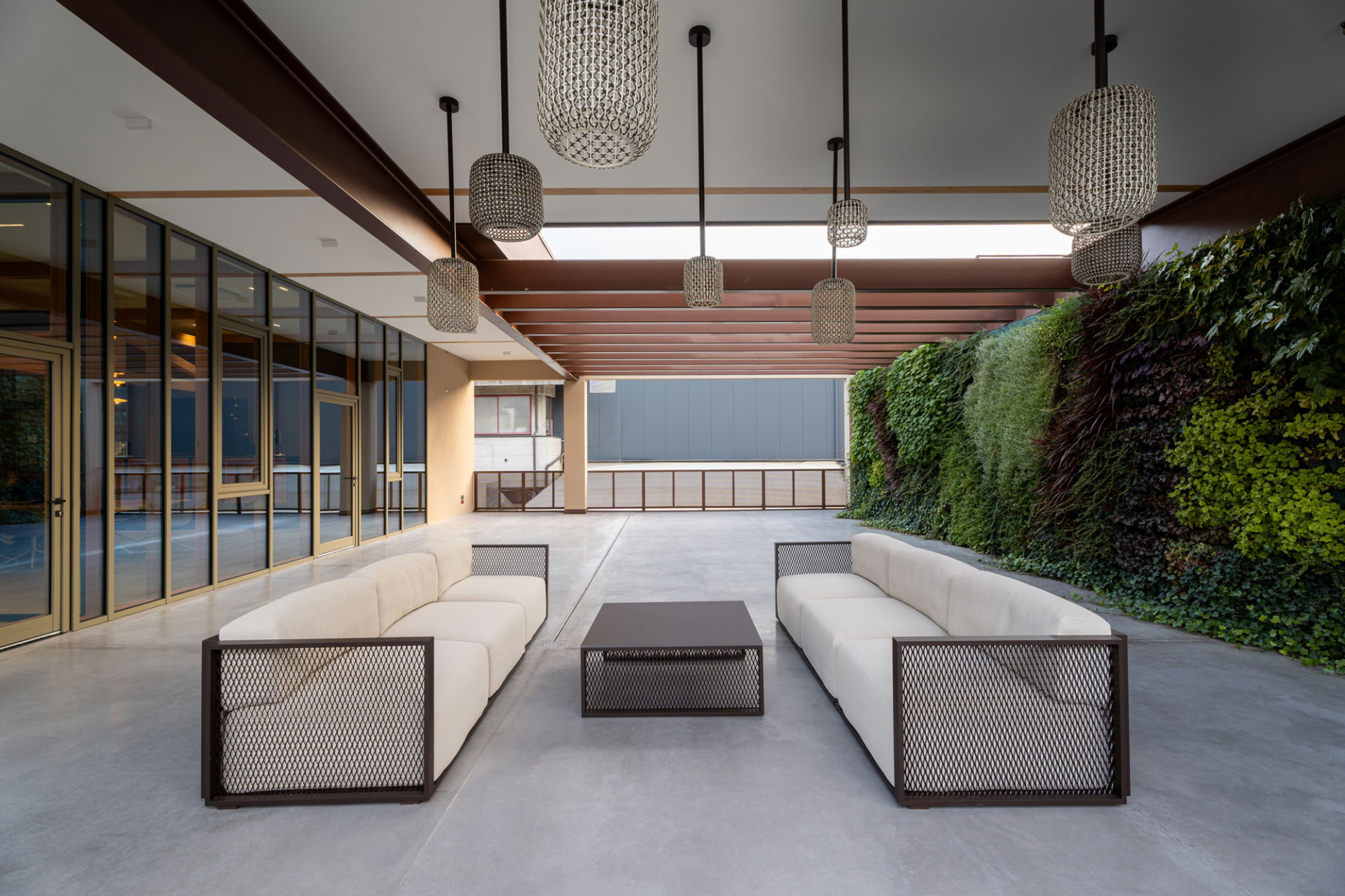 Ampia terrazza aziendale con pavimento in cemento nuvolato e vista panoramica, progetto uffici Omas Segusino