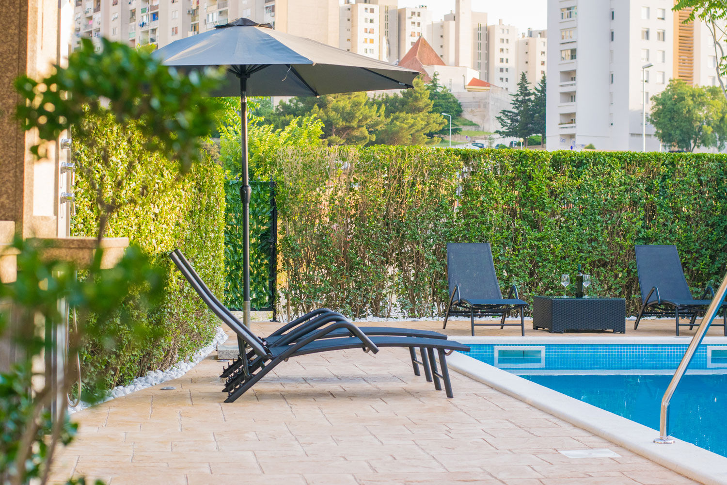 Zona piscina con pavimento antiscivolo in cemento stampato e finitura materica effetto pietra