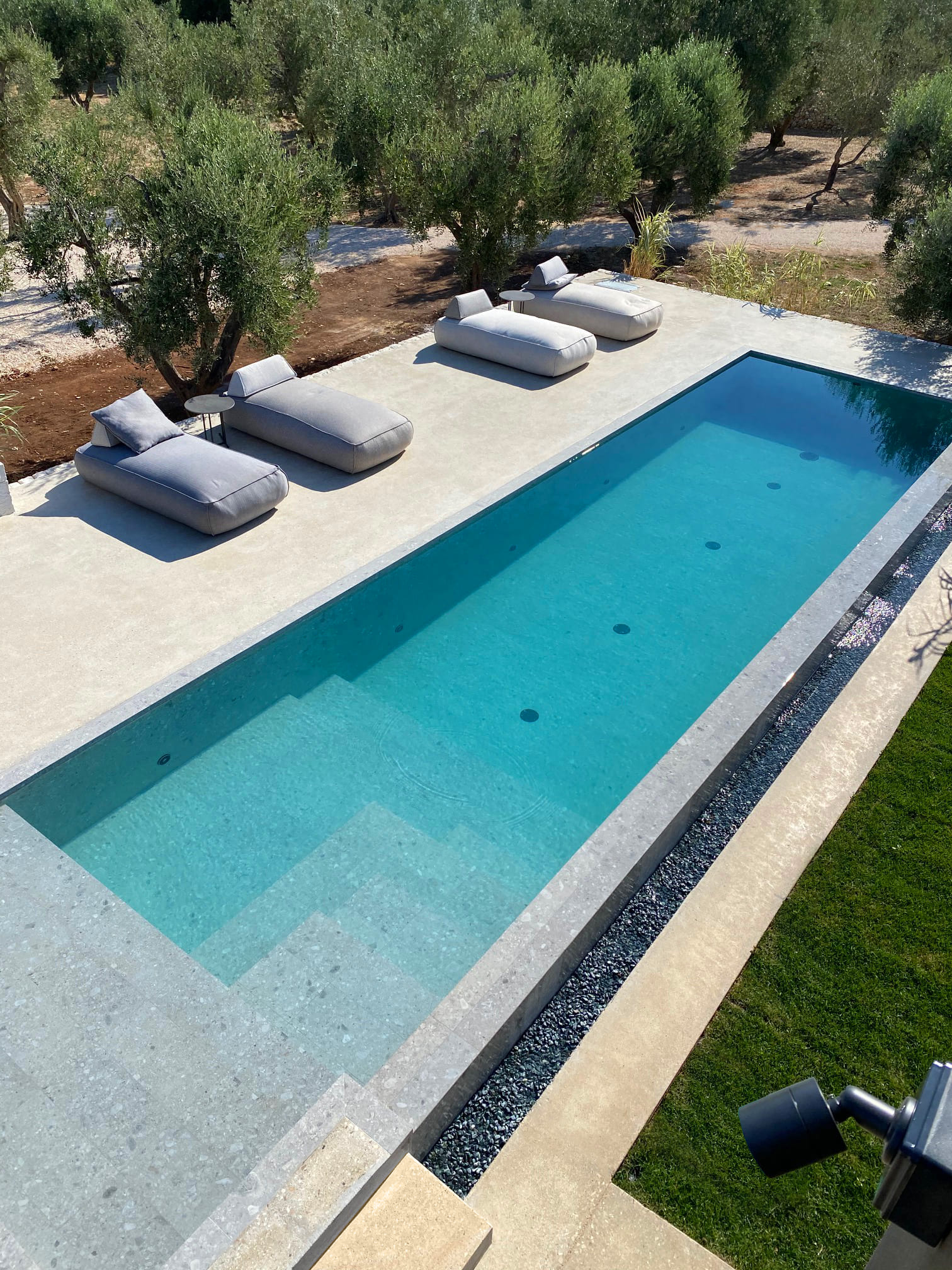 pavimentazione esterna piscina in microterrazzo antiscivolo texture fine villa con ulivi