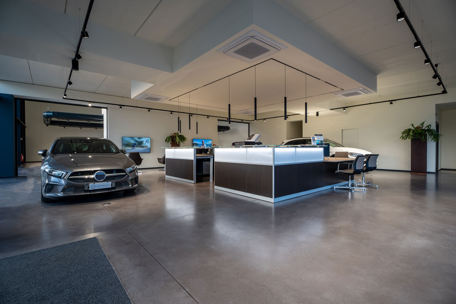 Deco Nuvolato Isoplam dark gray in showroom automobilistico contemporaneo con grandi superfici vetrate