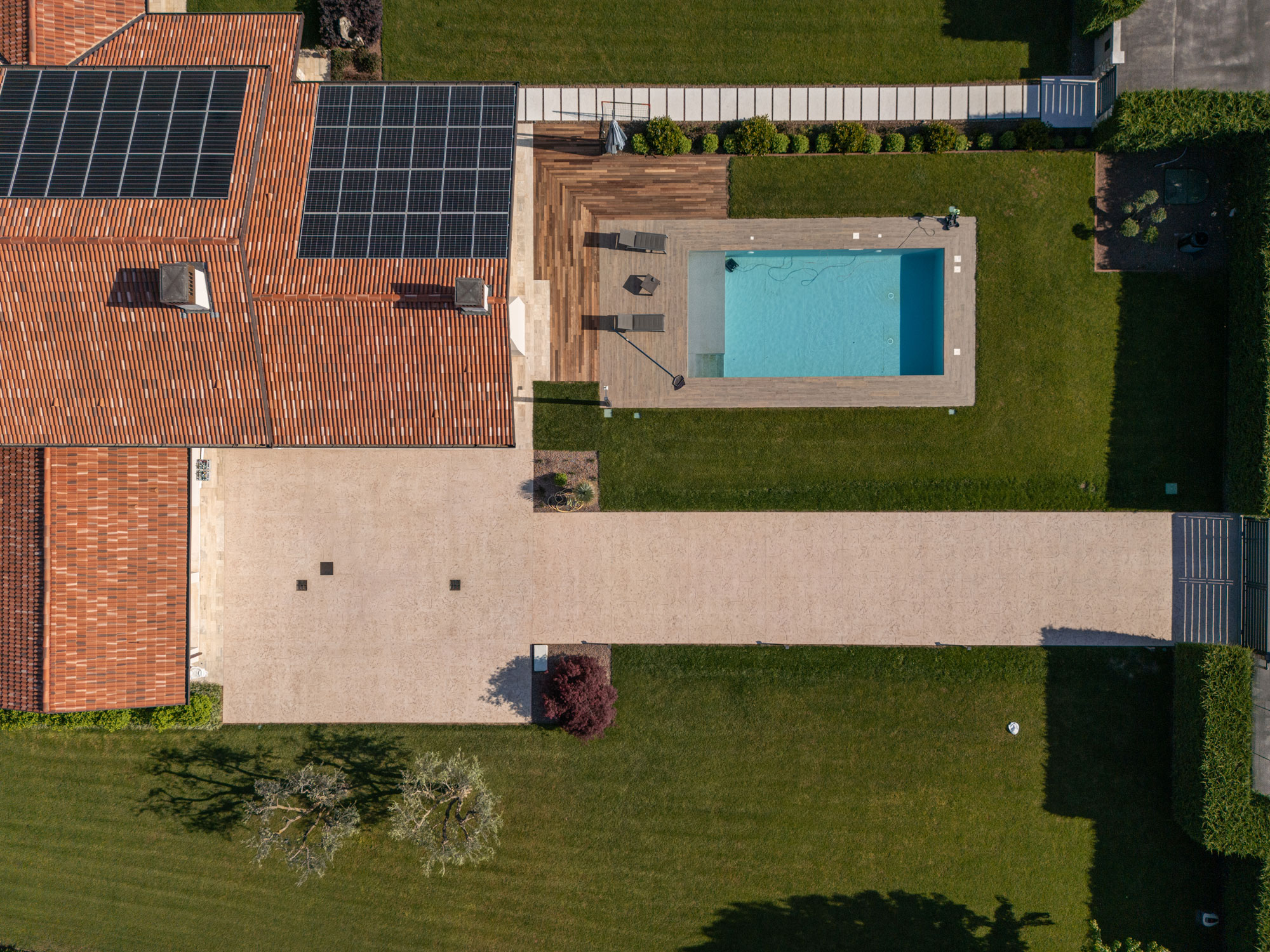 Vista aerea di villa contemporanea con pavimentazione stampata effetto roccia Isoplam e piscina immersa nel verde della campagna veneta
