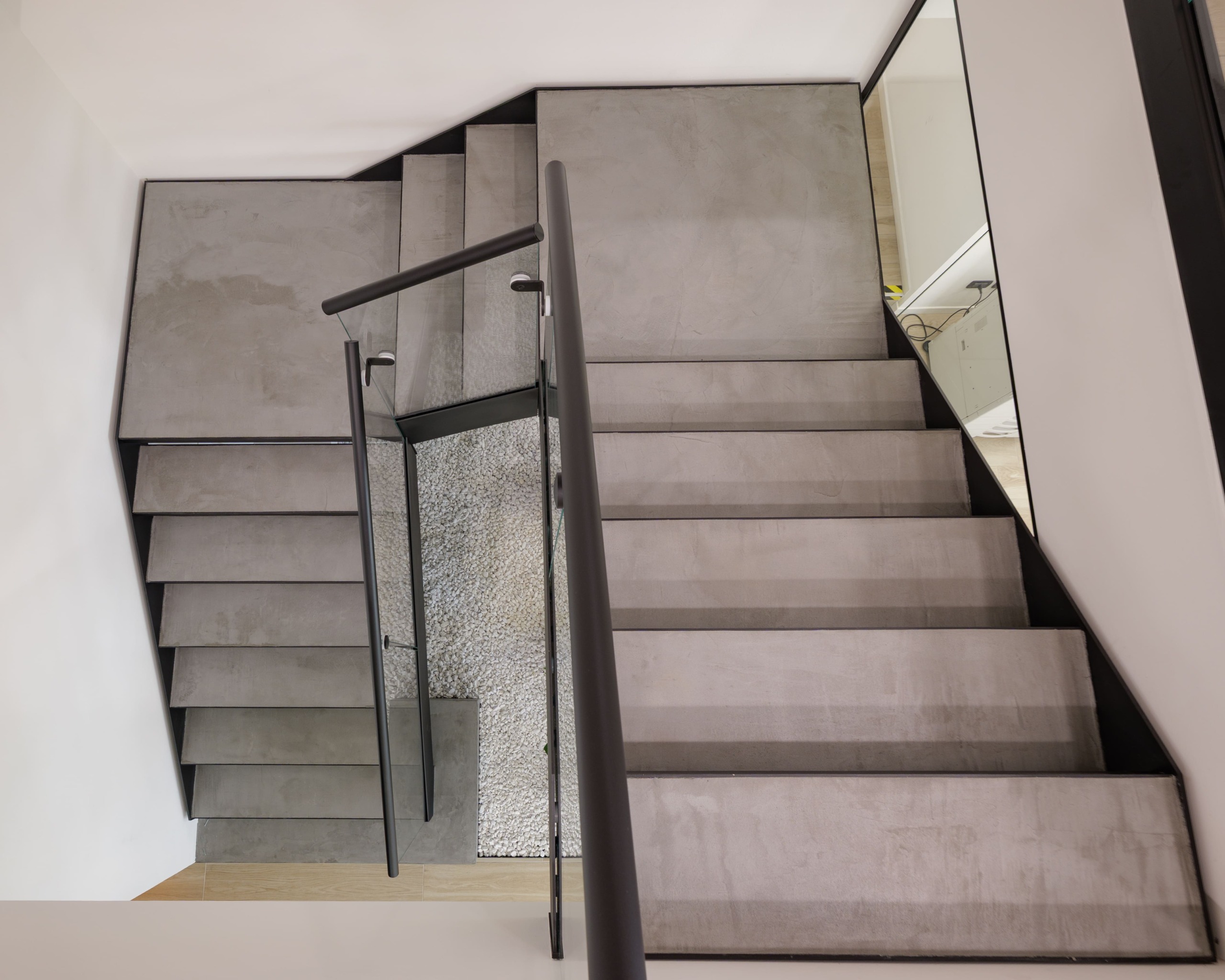 Rivestimento scala in metallo con microcemento Carbon Black negli uffici Adriacos a Latisana