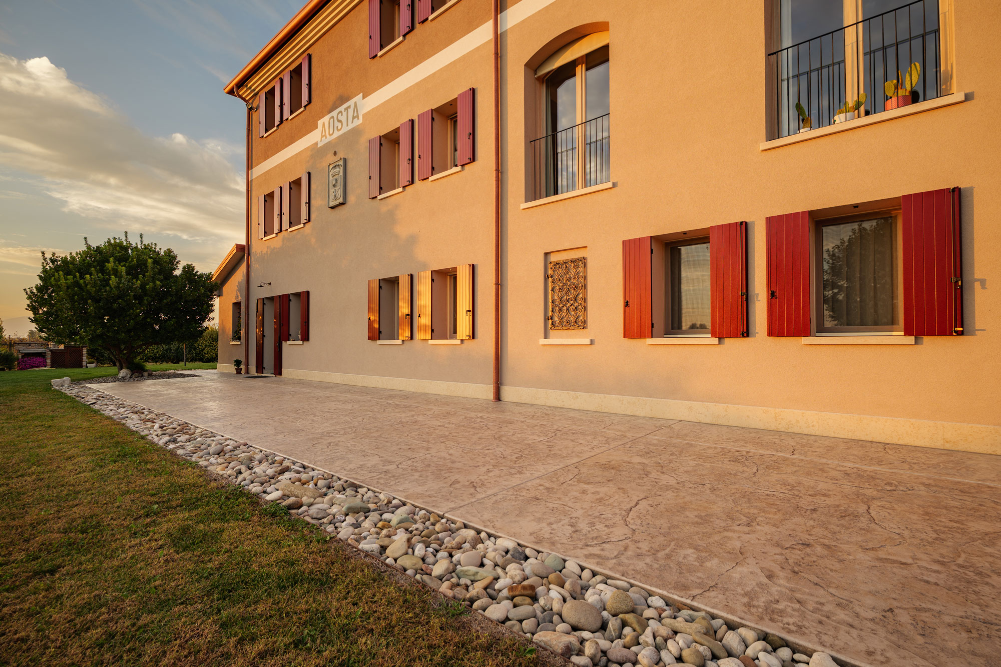 Pavimentazione esterna in cemento stampato effetto roccia Plam Stampable Isoplam illuminata dal tramonto